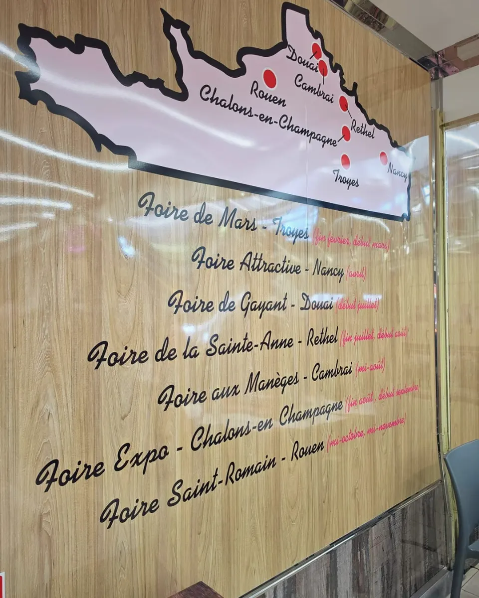 Panneau intérieur présentant une carte rose du nord de la France et la liste des foires visitées, de la Foire de Mars à Troyes à la Foire Saint Romain de Rouen