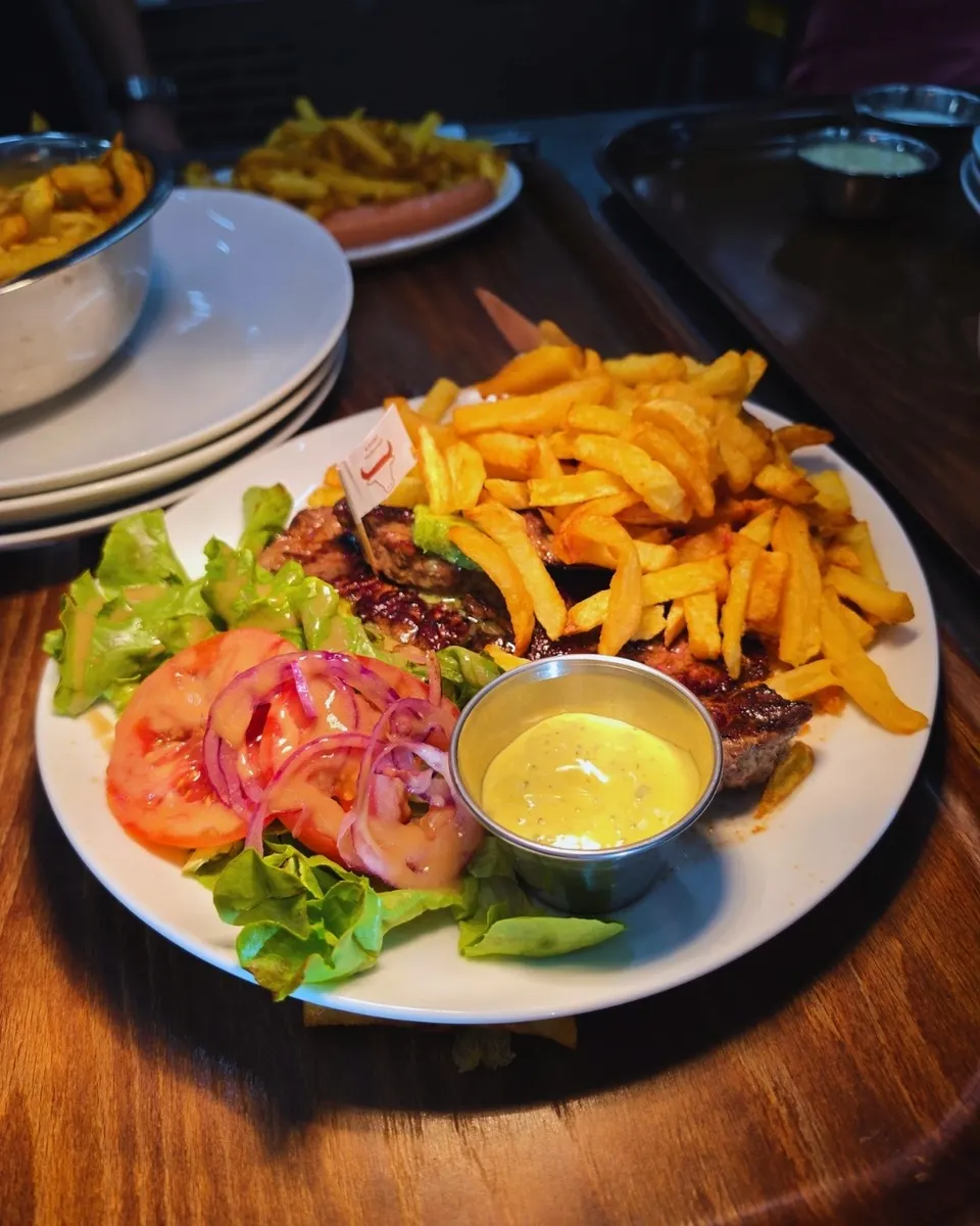 Pièce de bœuf grillée, montagne de frites maison, salade et sauce béarnaise.