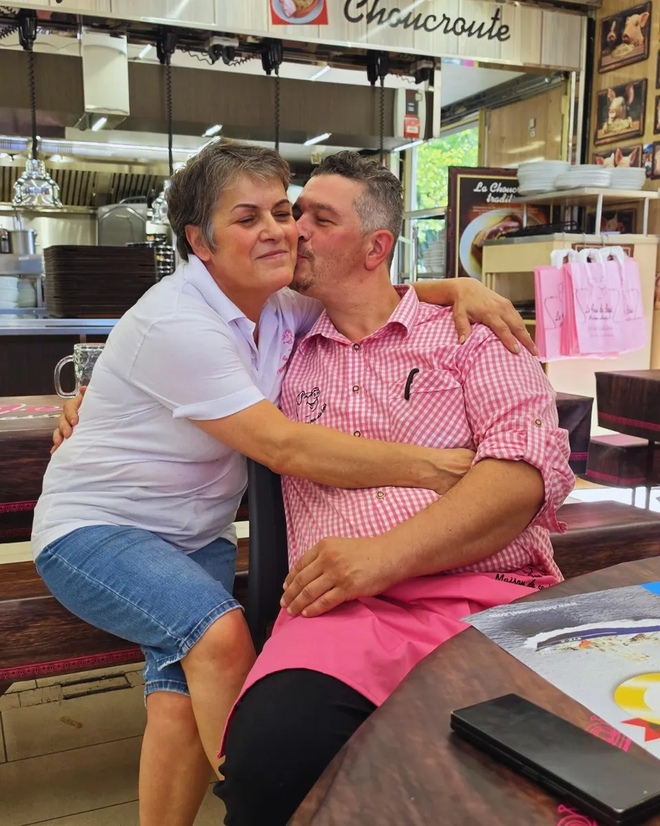 Moment de complicité entre les patrons : une bise sur la joue dans la brasserie décorée de sacs roses au cochon.
