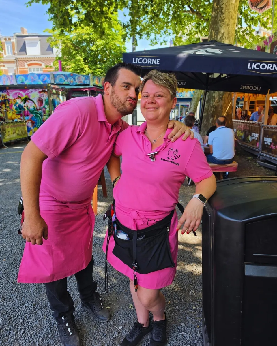 Duo complice de l'équipe en polos rose fuchsia sur la terrasse ensoleillée de la fête foraine.