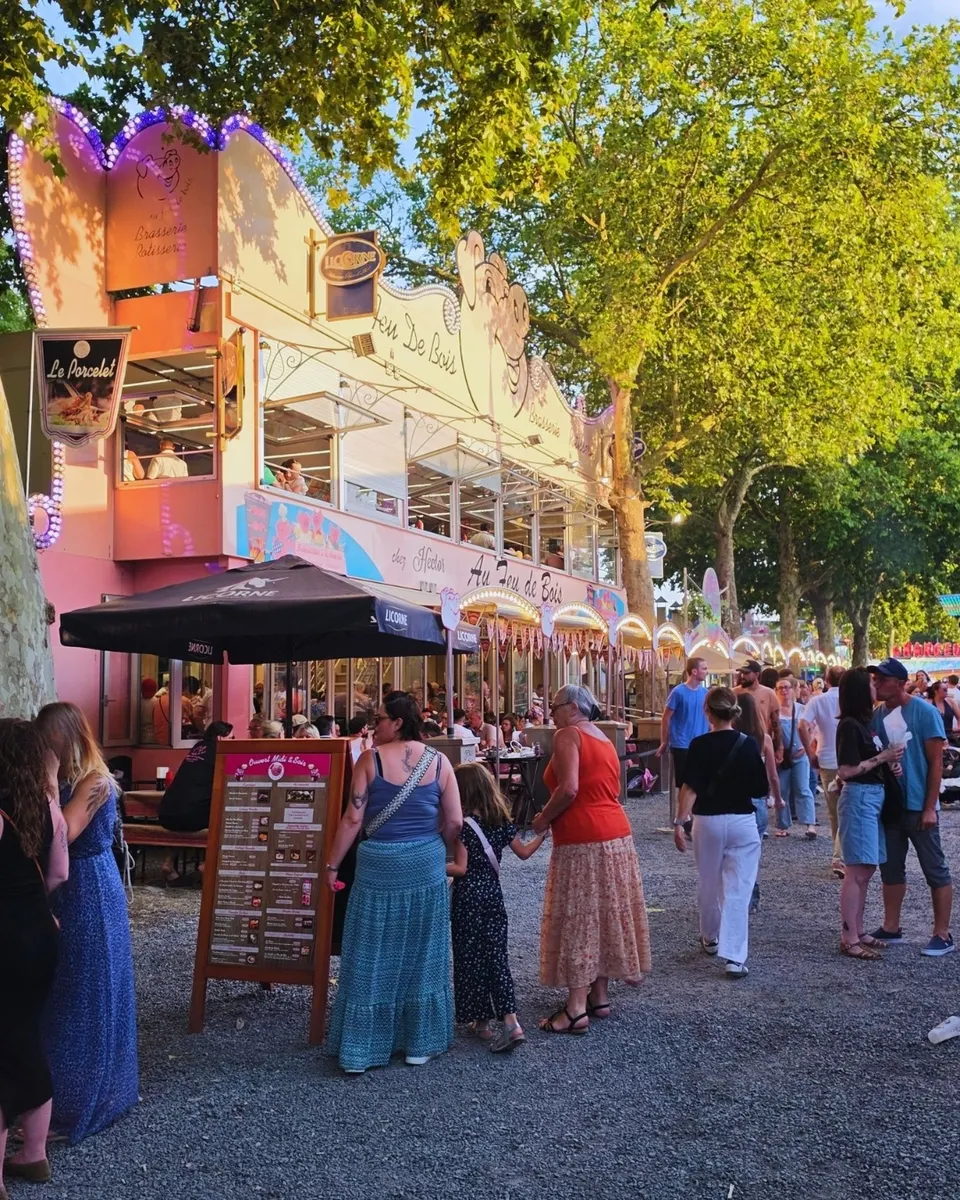 La foule des passants devant la façade rose du restaurant et l'enseigne Le Porcelet, en fin de journée.